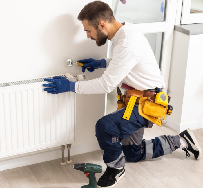 Chauffagiste professionnel réalisant la pose d’un radiateur